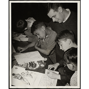 Art instructor Joseph Boutchia poses with four boys working on their projects at the Boys' Clubs of Boston