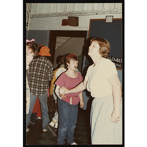 A woman hands a ball to a girl