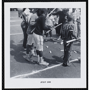 A group of boys play a fishing game on a playground during Tom Sawyer Day