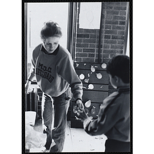 A woman helps a boy at a party