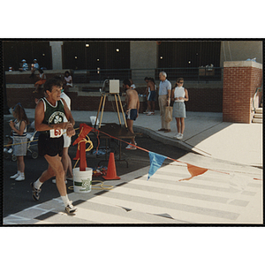 A man runs past spectators during the Battle of Bunker Hill Road Race