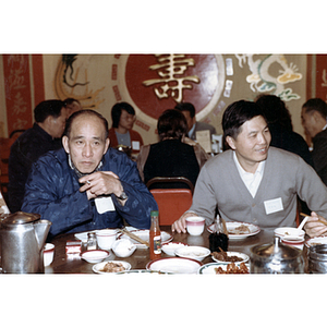 You King Yee and members of the Chinese Progressive Association eat with others at a restaurant table during a reception for the Consul General of Guangdong Province