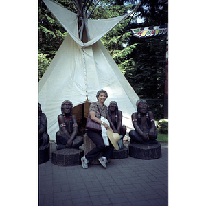 Chinese Progressive Association member poses with a teepee and Native American figures
