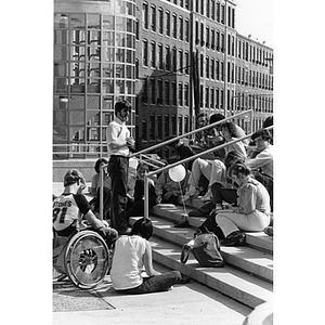 Students sit on steps outdoors for class on Richardson Plaza