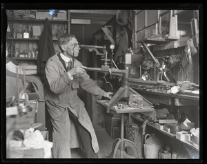 Walter G. Wolfe, industrial lens maker, at work in his shop