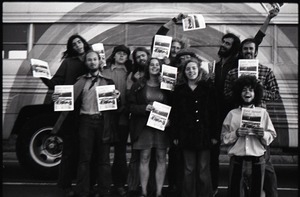 Free Spirit Press crew standing by bus, holding issues of the magazine (blurry)