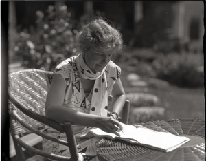 Dorothy Canfield Fisher: seated at a table outdoors, writing