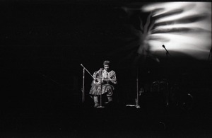 Taj Mahal in concert at Northfield, Mass.: Taj Mahal seated, playing guitar