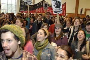UMass student strike: audience in the Student Union ballroom chanting and holding signs supporting a general student strike