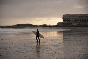 Surfer walking with his board toward the water