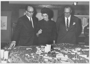 Dean Edward C. Moore with an unidentified woman and man standing above a scale model of the Umass campus