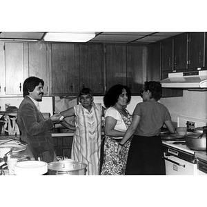Community members hanging out in the kitchen during a community gathering.
