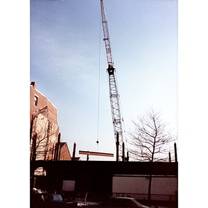 Crane swings a steel beam into place on the Taino Tower construction site.
