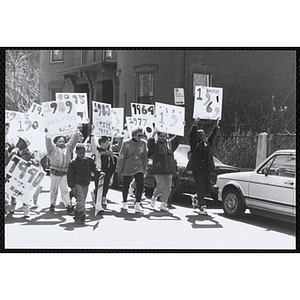 Children holding up their signs while marching down the street during the Boys and Girls Clubs of Boston 100th Anniversary Celebration Parade