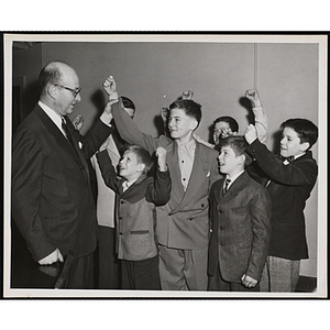 "The Winner and New Mayor of Boystown: Alan Steinert, chairman of the next Community Fund drive, raises the hand of Joseph Danesco, 12, in announcing Joe's victory in the annual Boystown election at the Roxbury Clubhouse of the Boys' Club of Boston, a Red Feather Service"