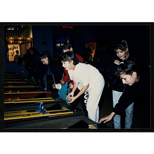 Girls play skeeball in a gaming arcade