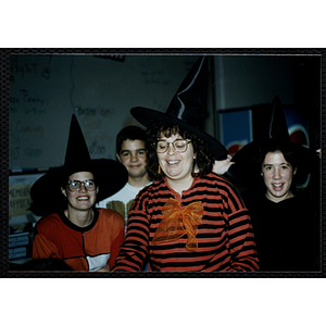 A woman and two girls wear witch hats at a Halloween event