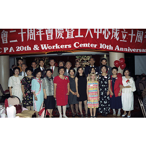 Group of people (including You King Yee and Lydia Lowe) poses under Chinese Progressive Association's 20th Anniversary Celebration banner