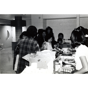 Chinese American adults and children filling their plates at a potluck buffet at the 29th anniversary celebration of the People's Republic of China held at the Josiah Quincy School
