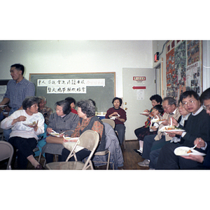 Adults and children attend a holiday party at the Chinese Progressive Association office