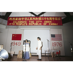 Two men and a woman prepare for the 27th anniversary celebration of the People's Republic of China, held in the Josiah Quincy School auditorium