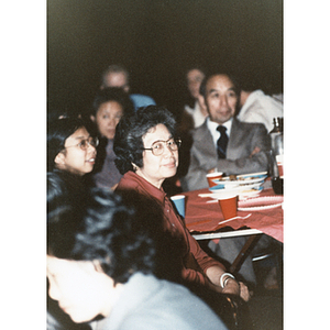 Woman sitting at a table and having dinner during a Chinese Progressive Association event