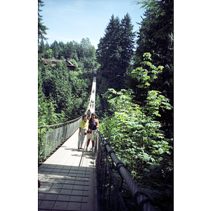 Two women stand on the Capilano Suspension Bridge in British Columbia's temperate rain forest