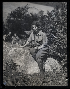 Elsie L. Higbee, seated on rocks in the Moose Hill Wildlife Sanctuary