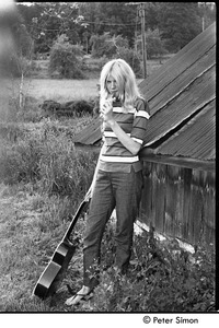 Karen Helberg eating a popsicle and holding a guitar