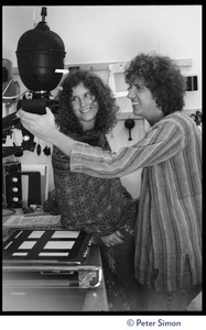 Usha (Cathy Brown) and Peter Simon in a darkroom, next to an enlarger