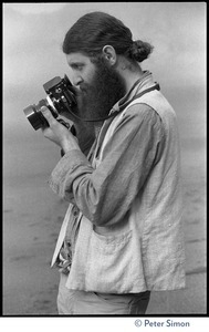 Rameshwar Das: half-length portrait with camera on the beach