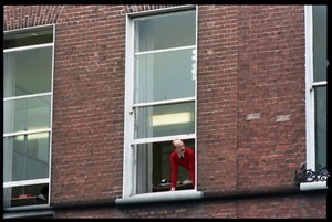 Man leaning out his window overlooking a Dublin street