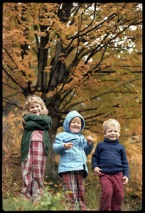 Three children in front of trees in high fall color, Montague Farm commune