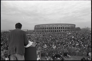 Anti-war rally at Soldier's Field, Harvard University: Howard Zinn speaking to crowd with Harvard Stadium in the background