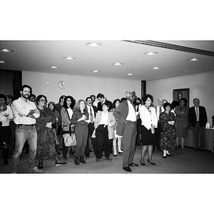 People gathered in a room for a reception and certificate presentation ceremony.