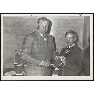 Former Boston Patriot Charlie Long presents an award to Francis Davis and shakes his hand at a Boys' Club awards ceremony