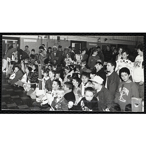 Children sit and stand in an auditorium, waiting for the "RoboCop" show, at a joint Charlestown Boys & Girls Club and Charlestown Against Drugs (CHAD) event