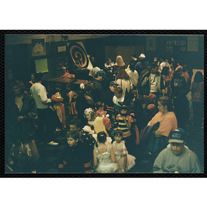 Adults and children in costumes gather for a Halloween party