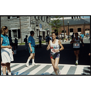 A woman crosses the finish line of the Battle of Bunker Hill Road Race