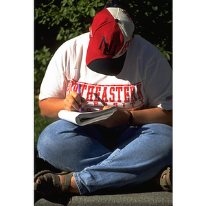 A student studies outdoors on the Northeastern campus
