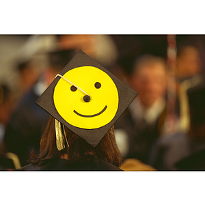 Student with smiley face on mortarboard at a Northeastern commencement ceremony