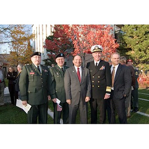 Several men, some in military dress, pose together at the Veterans Memorial dedication ceremony