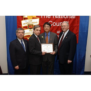 Dr. Homer H. Pien holds his certificate at The National Council Dinner