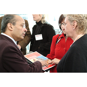 Mary Margaret Baker, '72, right, converses with other guests about the Northeastern Synthesis Research Magazine at the NU Today Cancer Research Panel luncheon