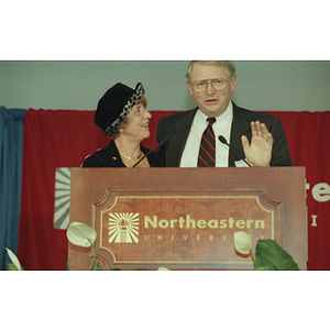 Neal Finnegan stands at the podium with a female speaker at the Behrakis Health Science Center groundbreaking