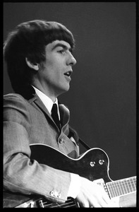 George Harrison playing guitar in concert with the Beatles, Washington Coliseum