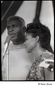 Party at Jackie Robinson's house: Rachel Robinson showing David Robinson  how to feed a baby with