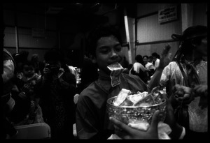 Cambodian New Year's celebration: drummer with money between his teeth and bowl