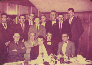 Faculty members gathered behind a dining table