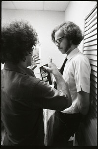 Abbie Hoffman with Steal This Book, talking to unidentified man